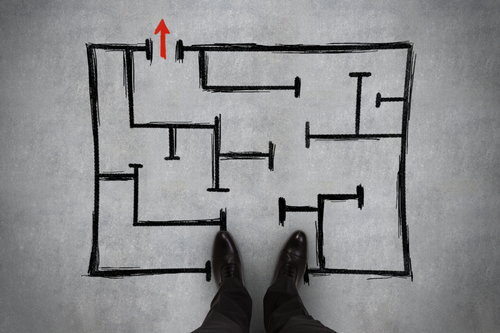 Feet standing in the beginning of a black drawn sketch on a concrete floor background, pathway and challenge concept