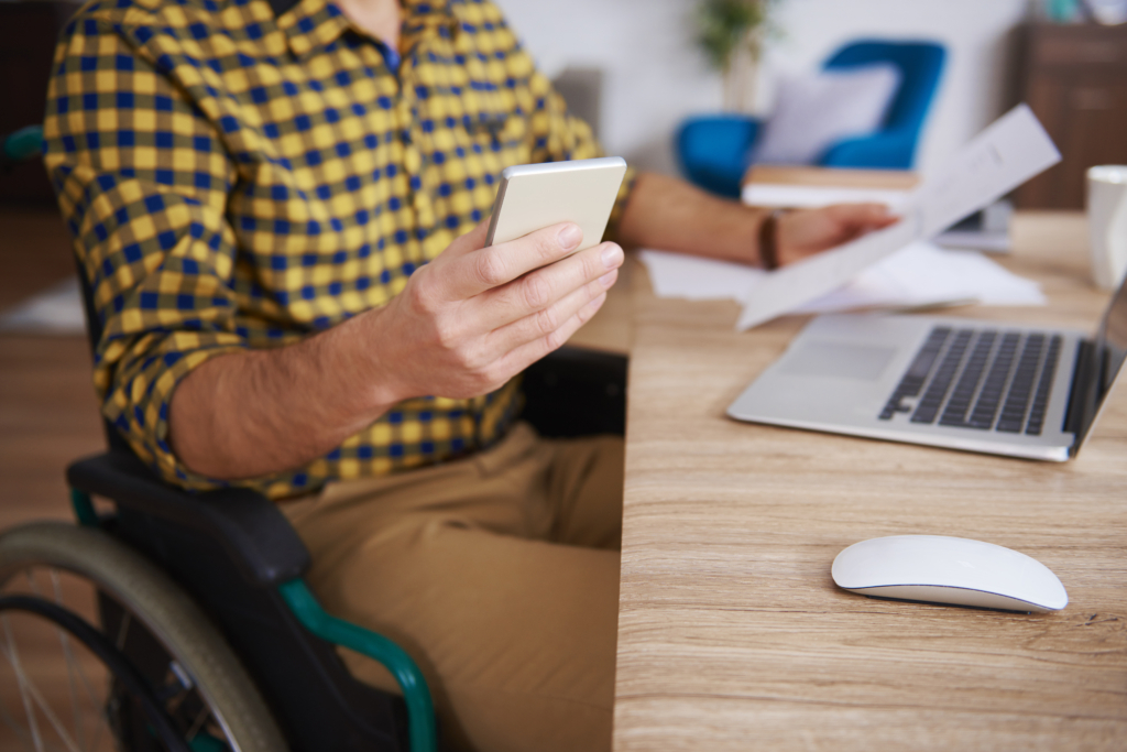 A person in a wheelchair using a website on a laptop, illustrating the importance of Shopify Store accessibility for people with disabilities.